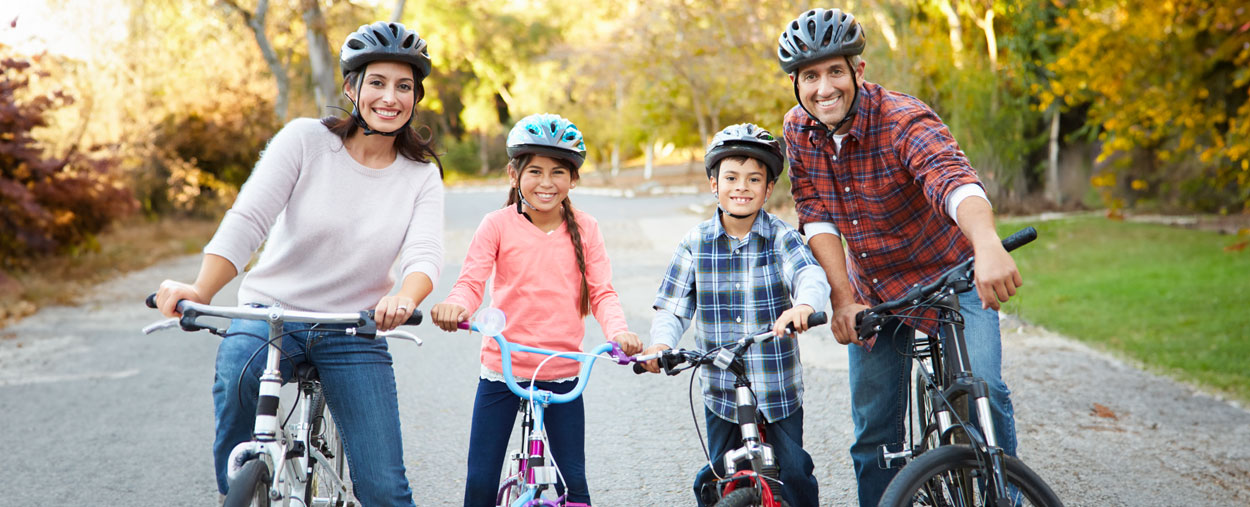 Family smiling and riding bicycles