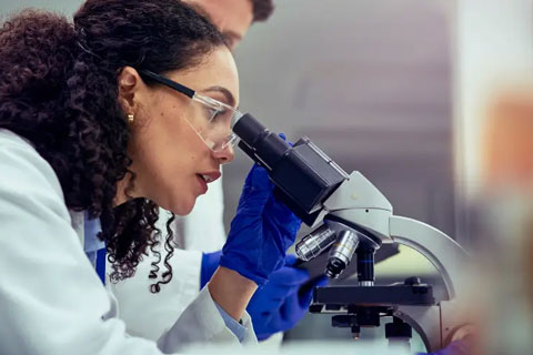 Scientist looking into a microscope