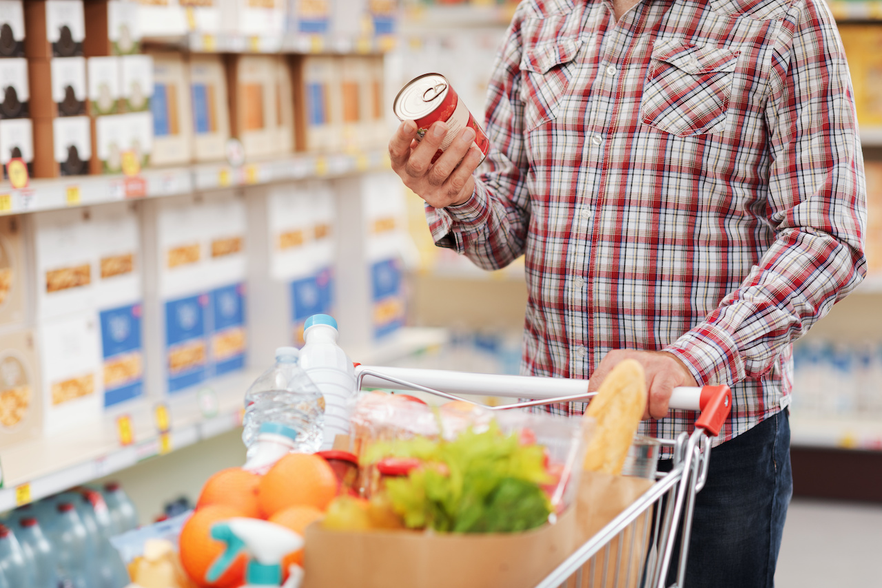 Man reading a food label at the supermarket jpeg